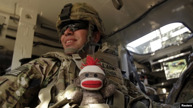 El soldado de EE.UU Moisés Ochoa del 2do Batallón de Infantería, lleva en su chaleco camuflado, a prueba de balas, un juguete de peluche para su hijo de nueve meses. El militar viaja a bordo de un vehículo blindado en la provincia de Kandahar, Afganistán.Foto: Reuters