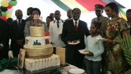 Zimbabwe President Robert Mugabe (4th R) and first lady Grace Mugabe (2nd R) stand with the president's birthday cake among guests on the occasion of his 89th birthday celebrations held in his honour at the State House, February 20, 2013, the eve of his birthday. Zimbabwe is expected to hold a constitutional referendum on March 16, 2013 and elections in July, which will end the unity government, but no dates have been set.  AFP PHOTO / JEKESAI NJIKIZANA