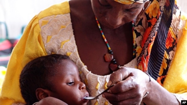Mother feeding her severely malnourished daughter at center in Niger run by CONCERN and supported by WFP in October 2010.