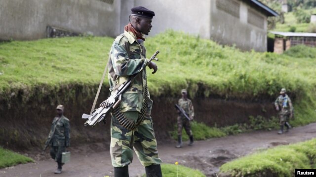 A M23 rebel fighter stands guard as they prepare for withdrawal from Karuba, some 62 kilometers west of Goma, DRC, November 28, 2012. 