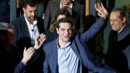 Head of Syriza party Alexis Tsipras waves while leaving the party headquarters after winning the elections in Athens, January 25, 2015.