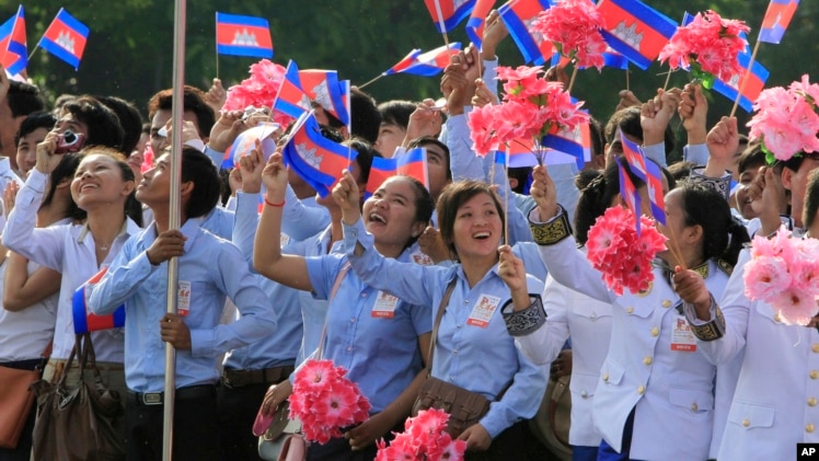 FILE - Cambodian students are seen waving national flags during Independence Day celebrations in Phnom Penh.