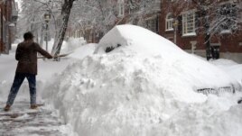A Boston, dans le Massachusetts, un habitant tente bravement de déblayer le trottoir