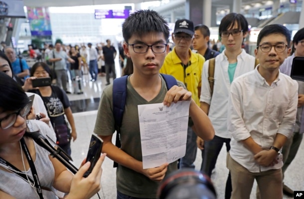 Hong Kong pro-democracy activist Joshua Wong, center, shows the letter from Thailand Immigration office after arriving at Hong Kong airport from Bangkok, Oct. 5, 2016.