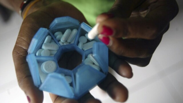 A patient infected with HIV prepares her medicines in this 2008 file photo