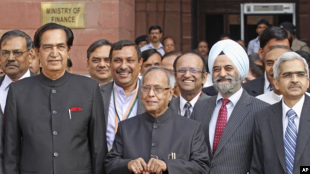 India's Finance Minister Pranab Mukherjee poses as he leaves his office to present the 2012/13 federal budget in New Delhi, March 16, 2012. 