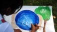 An Indian child paints during an awareness event organized by the Aakalpan Artist Society commemorating Earth Day in Allahabad, April 22, 2013.