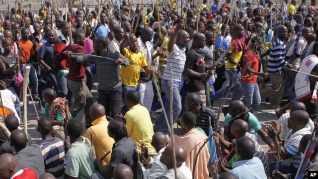 Striking mine workers armed with machetes, sticks, and spears march to a smelter plant at the Lonmin Platinum Mine near Rustenburg to hand over a memorandum to mine management and to ensure that workers had not reported for duty, Sept, 12, 2012.