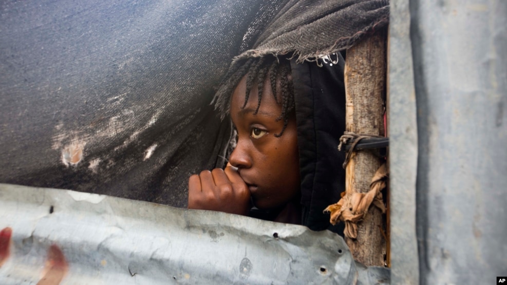 Một bé gái đang đợi để được sơ tán ra khỏi nhà tại Tabarre, Haiti. 