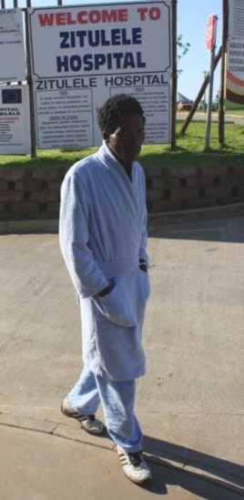 One of the physiotherapist’s patients, who previously could not even sit up in bed, takes a walk through the hospital grounds
