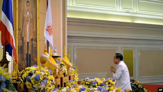 Tướng Prayuth Chan-ocha trước chân dung của Quốc vương Thái Lan Bhumibol Adulyadej sau lễ tuyên đọc một chiếu chỉ của Hoàng gia bổ nhiệm ông làm thủ tướng thứ 29 của vương quốc này.