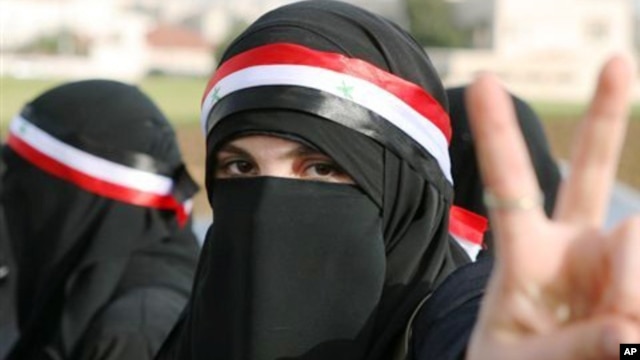 A Syrian protester flashes the victory sign during a protest calling for President Bashar Assad to step down in front of the Syrian embassy in Amman, Jordan, Sunday, April 17, 2011.