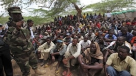 Members of al- Qaida-linked militant group al-Shabab listen to a Somalia government soldier after their surrender to the authorities in the north of Somalia's capital Mogadishu, September 24, 2012.