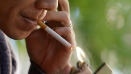 A man lights a cigarette at a cafe in Hanoi, Vietnam, November 12, 2012.