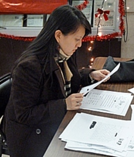 Substitute Santa Erica sifts through letters before deciding which child she will buy for.
