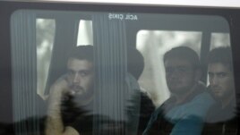 New Syrian refugees look out from their bus as they arrive at a refugee camp in the Turkish border town of Reyhanli in Hatay province July 29, 2012.