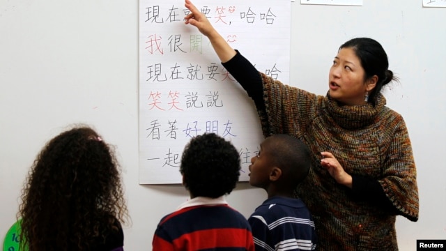 Teacher Kennis Wong (R) points to Chinese characters on a board at Broadway Elementary School in Venice, Los Angeles, California, Apr. 11, 2011. 