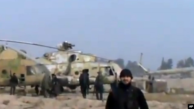 In this image taken from video obtained from the Ugarit News, which has been authenticated based on its contents and other AP reporting, Syrian rebels capture a helicopter air base near the capital Damascus after fierce fighting in Syria, on Sunday, Nov.