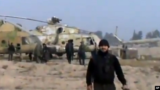 In this image taken from video obtained from the Ugarit News, which has been authenticated based on its contents and other AP reporting, Syrian rebels capture a helicopter air base near the capital Damascus after fierce fighting in Syria, on Sunday, Nov. 