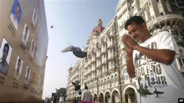 Một người cầu nguyện bên ngoài khách sạn Taj Mahal Palace.