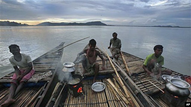 Fishermen prepare food on their boat on the River Brahmaputra in Gauhati, in the northeastern Indian state of Assam, June 15, 2011