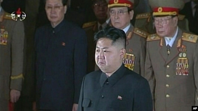 New North Korean ruler Kim Jong Un (front) pays his respects to his father and former leader Kim Jong Il, lying in state at the Kumsusan Memorial Palace in Pyongyang, December 20, 2011.
