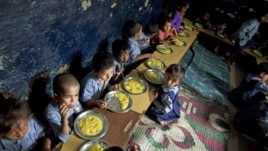 Children eat a meal at a school in a shanty neighborhood of New Delhi, India, Sept. 13, 2012.