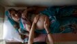 Suman, a 25-year-old pregnant woman, lies on an examination table as a nurse places her hands on her stomach during a check up at a community health centre in the remote village of Chharchh, in the central Indian state of Madhya Pradesh.