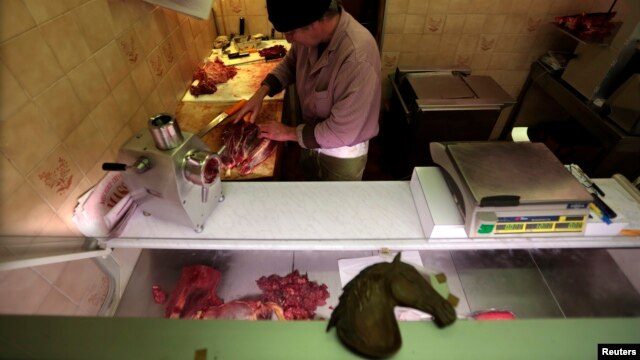 Charles Massa, a butcher, prepares horsemeat in his horse butchery shop, Nice, France, Feb. 14, 2013.