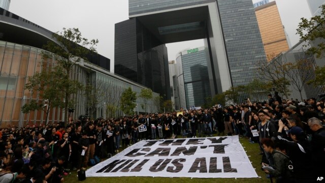 Các nhà báo và người ủng hộ đứng cạnh một biểu ngữ lớn với hàng chữ "Họ không thể giết tất cả chúng ta" bên ngoài trụ sở chính phủ ở Hồng Kông, ngày 2/3/2014.