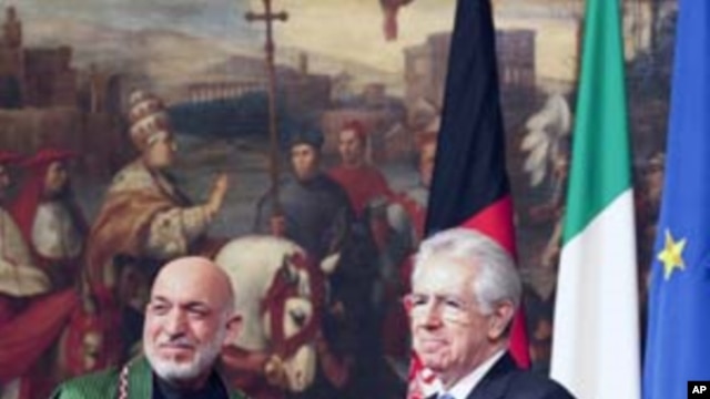 Italian Prime Minister Mario Monti (R) and Afghanistan's President Hamid Karzai shake hands after signing of documents during a meeting at the Chigi Palace in Rome January 26, 2012.