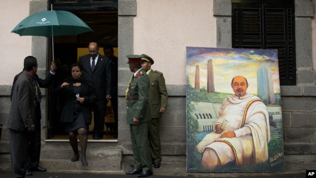Sudan's President Omar al-Bashir, in doorway, walks past a portrait of late Ethiopian Prime Minister Meles Zenawi, a gift from another delegation, as he arrives to pay his respects to Meles' body lying in state at the national palace in Addis Ababa, Ethio