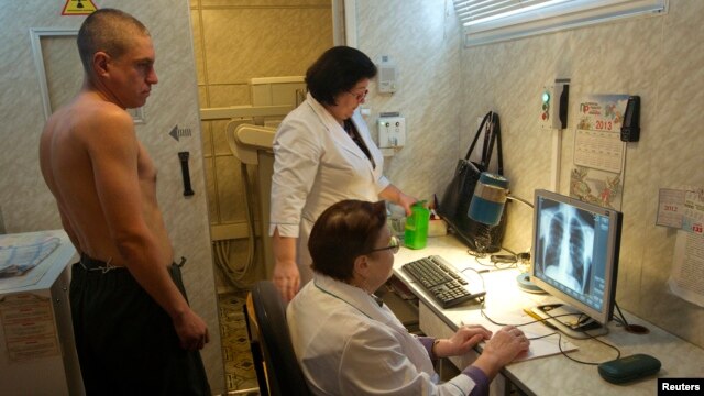 A man (L) is x-rayed to detect tuberculosis during a medical examination, Jan. 29, 2013.