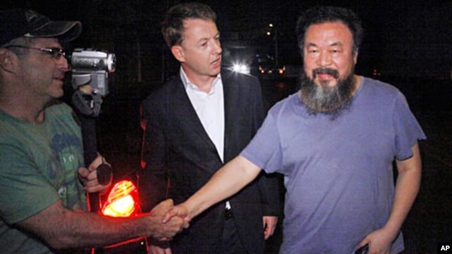Activist artist Ai Weiwei (R) shakes hand with unidentified foreign journalists gathered outside his home in Beijing, June 22, 2011