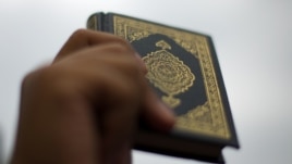 A protester holds up a copy of the the Koran during a demonstration in front of the US Embassy Kuala Lumpur, Malaysia, February 2012. 