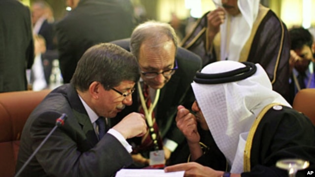 Turkey's FM Ahmet Davutoglu (L) confers with United Arab Emirates' (UAE) FM Sheikh Abdullah bin Zayed al-Nahyan during the Friends of Syria Conference in Tunis, February 24, 2012