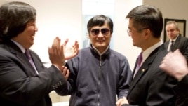 In this photo released by the U.S. Embassy Beijing Press Office, blind lawyer Chen Guangcheng is wheeled into a hospital by U.S. Ambassador to China Gary Locke, right, and an unidentified official at left, in Beijing, May 2, 2012. 