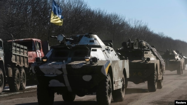 Ukrainian servicemen ride on military vehicles as they leave an area around Debaltseve, eastern Ukraine near Artemivsk, February 18, 2015.