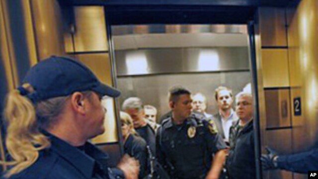 Escorted by law enforcement officers, Wisconsin Assembly Republicans exit the state Capitol after cutting off debate and rapidly voting to pass a controversial budget repair bill, February 25, 2011