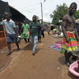 Ethnic Gueres carry a dead relative inside a temporary refugee camp set up at a Catholic church in Duekoue, Ivory Coast, May 2011.