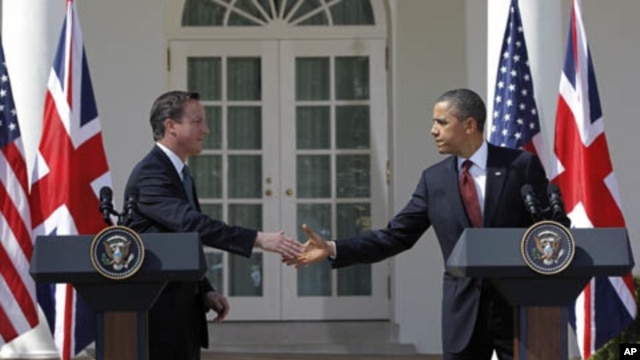 British Prime Minister David Cameron and President Barack Obama reach to shake hands during their joint news conference in the Rose Garden of the White House in Washington, March 14, 2012. 