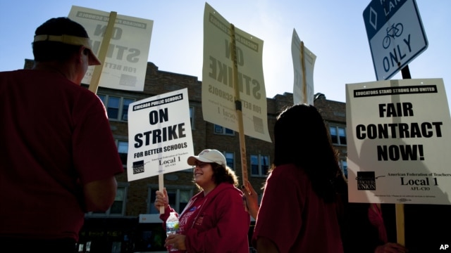 Public school teachers picket outside Amundsen High School in Chicago on the first day of a strike by the Chicago Teachers Union, Monday, Sept. 10, 2012.