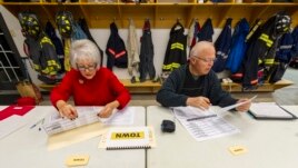 Nhân viên bầu cử chuẩn bị danh sách cử tri trước khi phòng phiếu mở cửa tại Avon, Indiana.