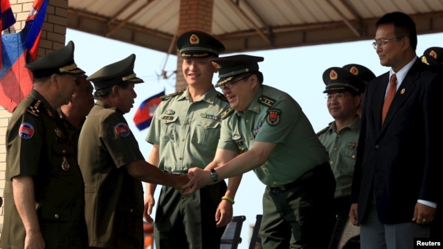 In this March 2015 file photo, Cambodian Defense Minister Tea Banh, second left, shakes hands with a Chinese army adviser during a graduation ceremony at the Army Institute in Kampong Speu province. (REUTERS/Samrang Pring)