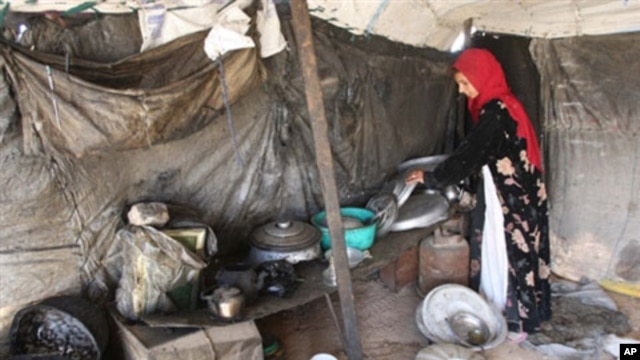 A refugee woman originally from the western Iraqi desert region, packs away pots and pans in her tent home several kilometers from the southern holy city of Karbala, some 110 kms from Baghdad (2009 file photo)
