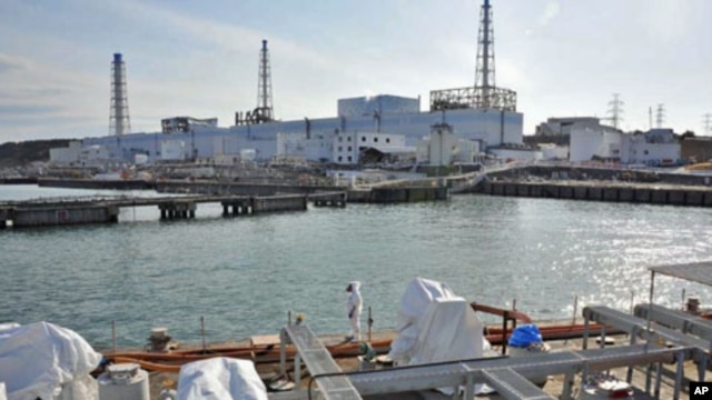A US military barge carrying pure water (bottom) leaves the quay near Tokyo Electric Power Co.'s Fukushima Daiichi Nuclear Power Plant, April 4, 2011