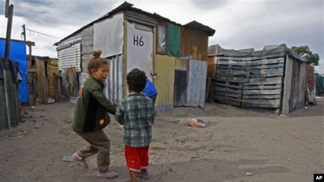 Children play outside a house in a township on the outskirts of Cape Town, South Africa, 27 May 2010