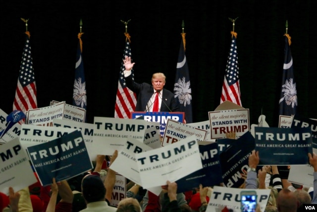 Donald Trump waves to the crowd at a rally in Myrtle Beach, S.C., a day ahead of the state's Republican presidential primary, Feb. 19, 2016. (B. Allen/VOA)