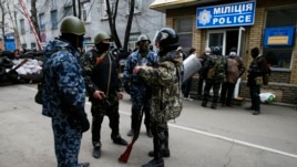 Armed men stand in front of police headquarters in Slaviansk, April 12, 2014.
