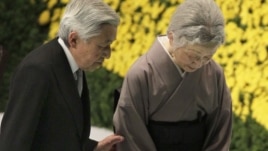 Japan's Emperor Akihito, left, escorts Empress Michiko after offering prayers for the war dead during a memorial service at Budokan Martial Arts Hall in Tokyo, Aug. 15, 2012.